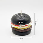 Pepper & White handcrafted burger candle with a black bun, smiling face, and detailed food layers on white background