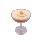 Pepper & White Mimosa Bloom chamomile scented candle in a glass coupe with a decorative daisy wax topper