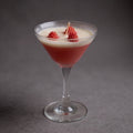 Pepper & White Scarlet Sip cranberry scented candle in a martini glass with wax raspberry decorations