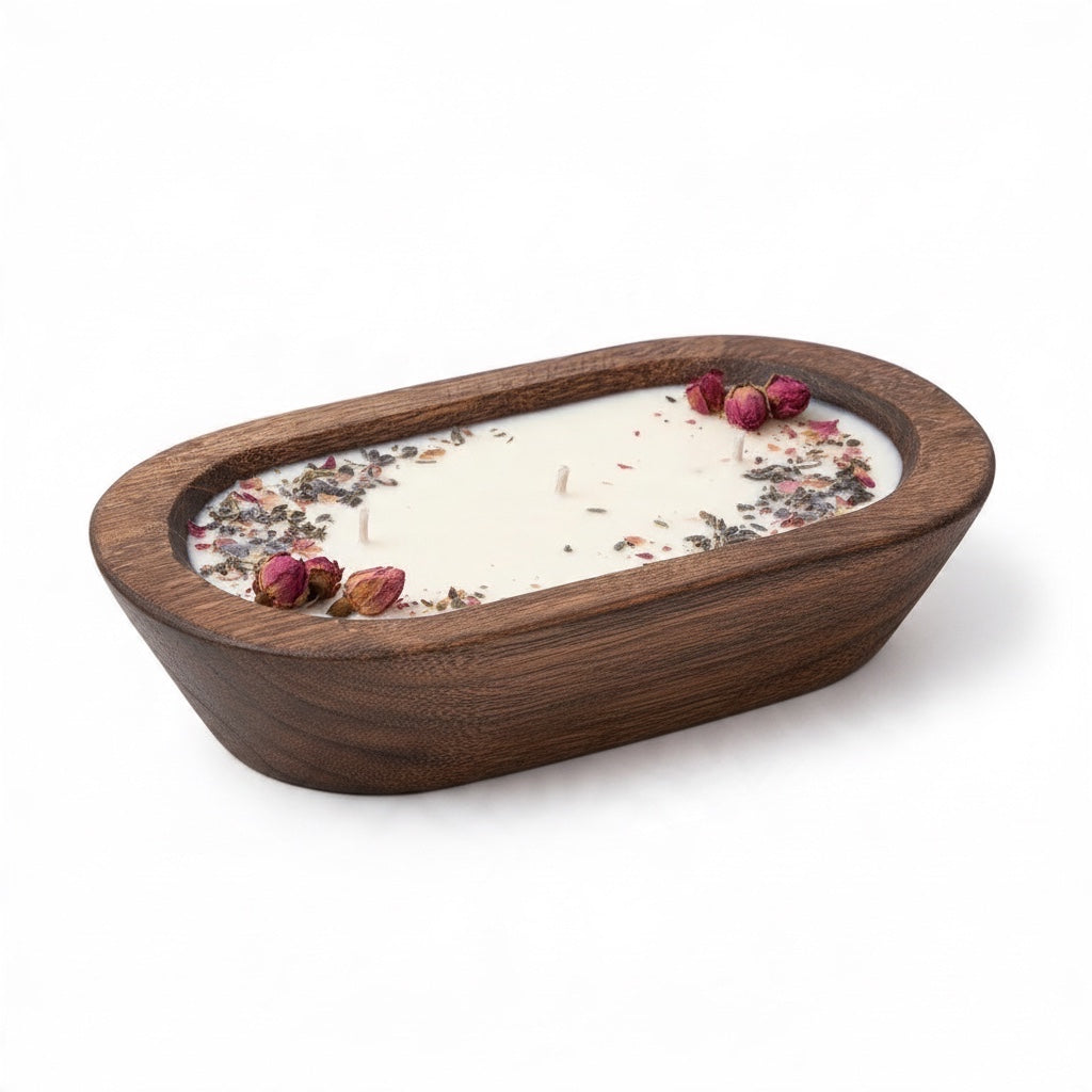 Pepper & White Fireside soy wax candle in a hand-carved oval wooden bowl topped with dried rosebuds and lavender