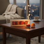 Pepper & White Boondi Laddu shaped festive candles in orange and red, displayed on a wooden table with gift box.