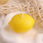 Pepper & White lemon-shaped yellow wax candle with realistic textured peel on a white surface.