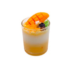 Pepper & White Tropical Delight mango scented dessert candle in a glass cup topped with fresh mango slices and fruit pieces