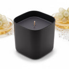 Pepper & White Noir Champagne 280g scented candle in a matte black square container with white grapes on the side