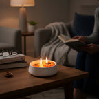 Pepper & White sunflower soy wax candle with three lit wicks in a white ceramic bowl on a cozy living room table.