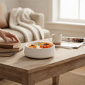 Pepper & White sunflower shaped soy wax candle in a white ceramic bowl on a wooden coffee table in a cozy living room
